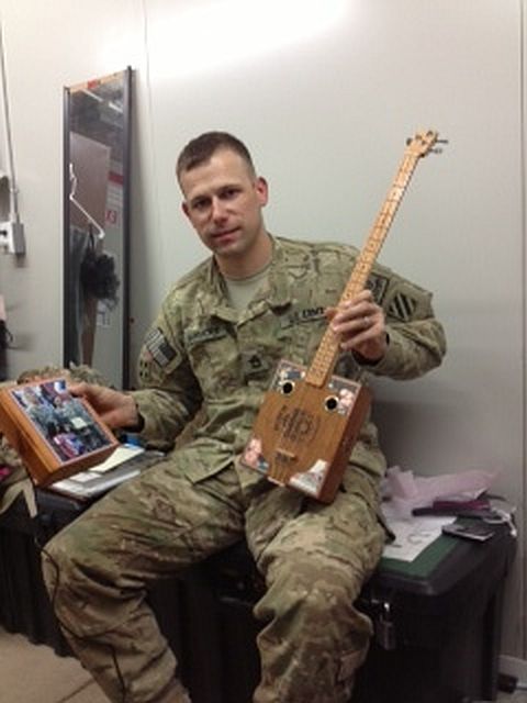 Service member with cigar box guitar