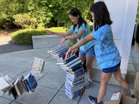 Students toppling a pile of books