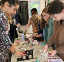 Students crafting designs for pin-back buttons