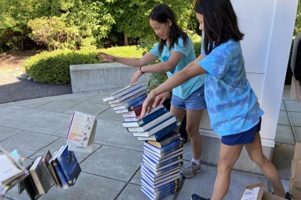Students toppling a pile of books